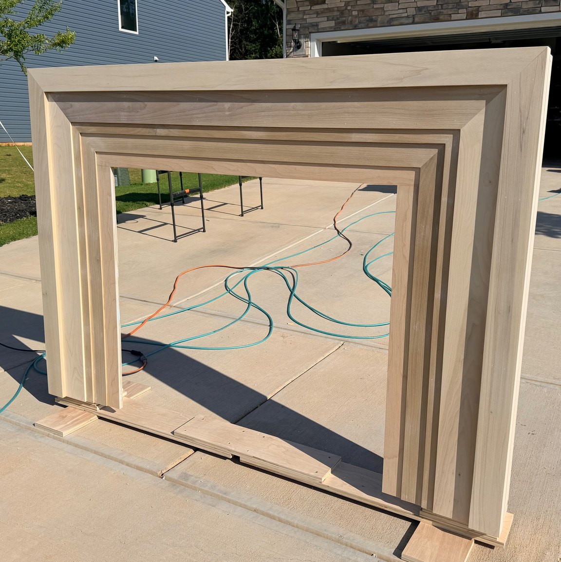 The same surround in raw wood before finishing, the stacked trim layers and mitered build-up still visible