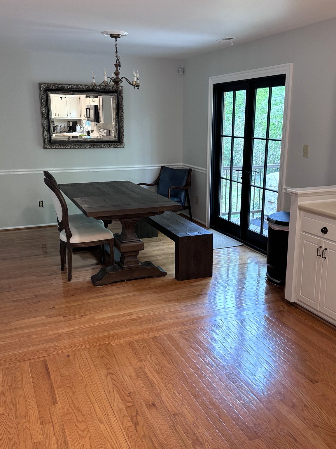 The opened-up living space with a new chair rail, blended oak flooring and black-framed French doors